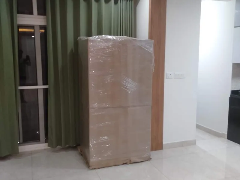 Tall cabinet unit wrapped in corrugated cardboard sheets in living room