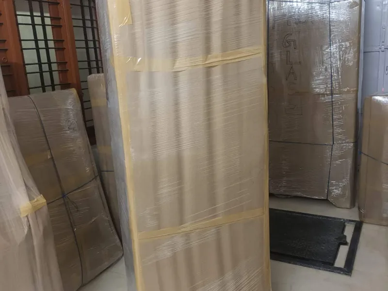 Tall bedroom cupboard wrapped in brown corrugated board with securing tape