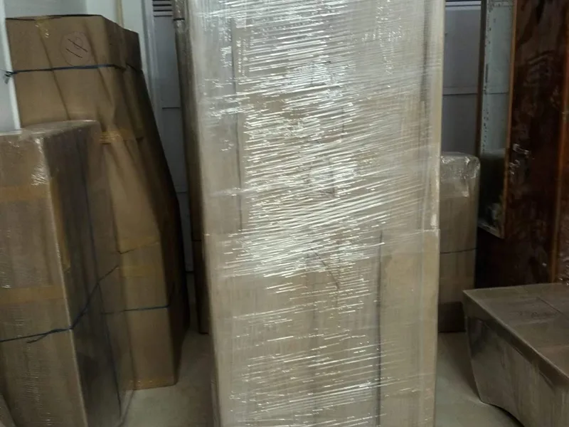 Large double-door refrigerator wrapped in shock-absorbing film and corrugated cardboard