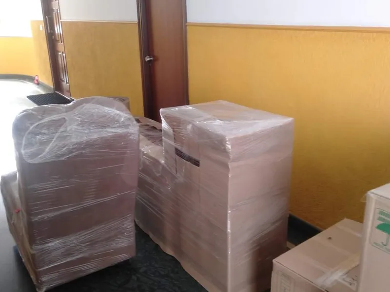 Group of packed moving boxes and wrapped household items staged near exit door