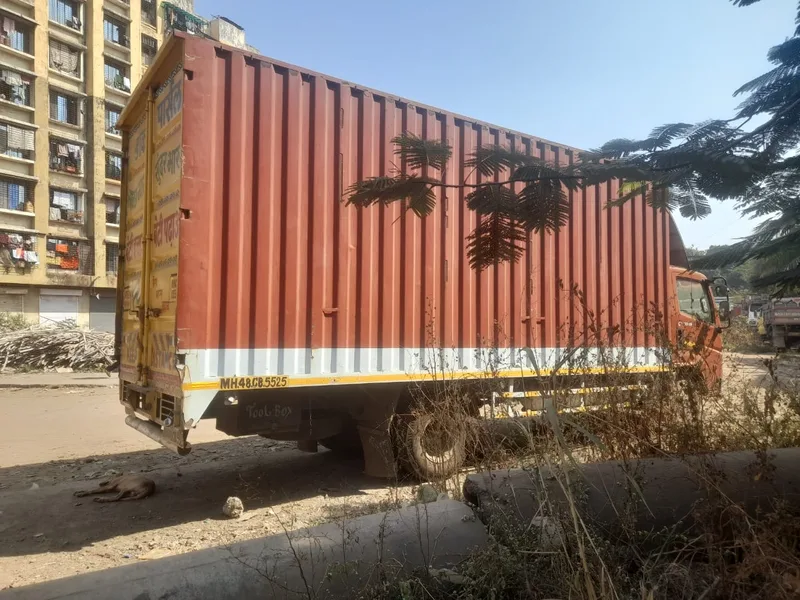 Container transport truck parked in front of residential apartment community
